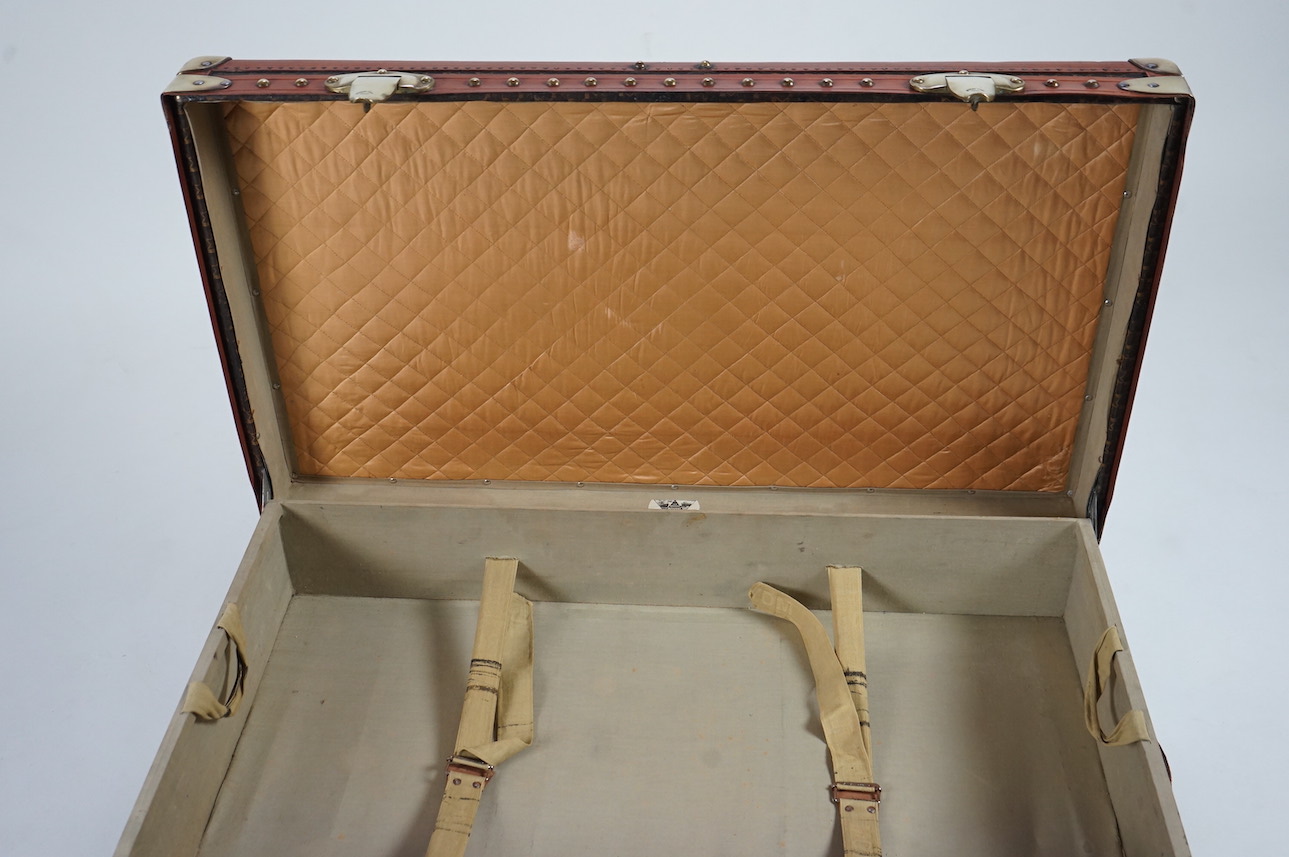 A vintage Moynat cabin trunk, with brass mounts, wooden slats and tan leather bound M motif canvas, the interior with quilted lining inside the lid and two canvas trays, 90cm wide, 53cm deep, 33cm high. Condition - very